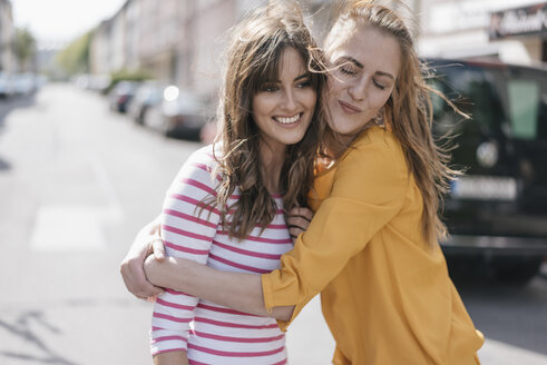 Zwei Freundinnen umarmen sich in der Stadt - JOSF02403