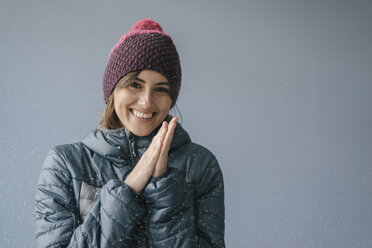 Woman wearing woolly hat in snow, portrait - JOSF02412