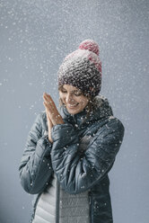 Woman wearing woolly hat in snow, portrait - JOSF02413