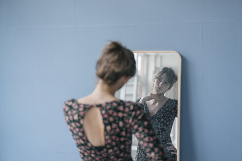 Young woman in vintage dress looking into mirror - JOSF02420