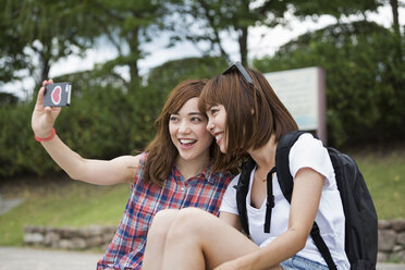 Zwei Frauen, Freundinnen, machen ein Selfie im Park. - MINF02236