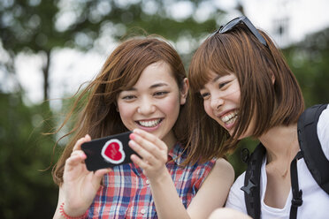 Zwei Frauen, Freundinnen, machen ein Selfie im Park. - MINF02238