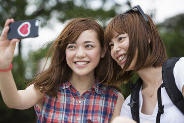 Zwei Frauen, Freundinnen, machen ein Selfie im Park. - MINF02239