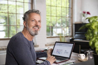 Mature man working in his home office at a loft apartment - FKF03040