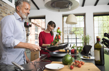 Couple in kitchen, preparing food toghether - FKF03093