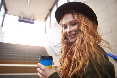 Porträt einer lächelnden rothaarigen Frau mit Kaffee zum Mitnehmen - ABIF00759