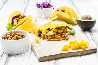 Vegetarische Tacos gefüllt mit in Curcuma gerösteten Kichererbsen, gelber Paprika, Avocado, Salat und Rotkohl - LVF07324