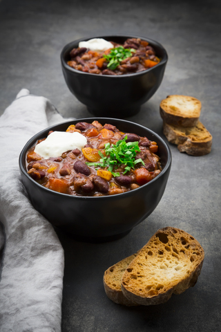 Two bowls of Chili con Carne with fresh coriander and sour cream stock photo