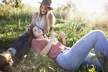 Apfelgarten, zwei Frauen liegen im Gras. - MINF02296