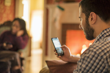 Ein Mann überprüft sein Handy und lächelt. - MINF02342