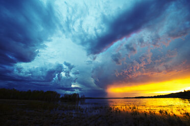Sonnenuntergang am Horizont über einem See, und aufziehende Gewitterwolken. - MINF02355