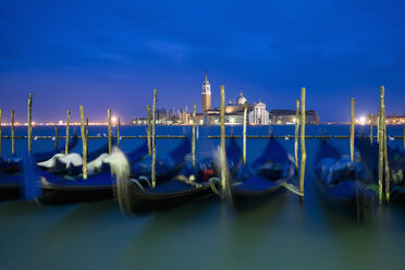 A view from the Riva degli Schiavoni and the Piazza San Marco across the water to the island and church of San Giorgio Maggiore. Gondolas moored at dusk. - MINF02363