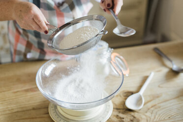 Eine Frau misst und siebt Weißmehl. Backen zu Hause. - MINF02392