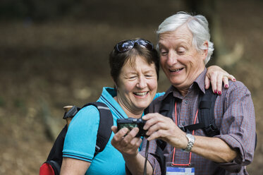 Ein reifes Paar schaut lachend in eine Digitalkamera. - MINF02408