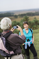 A mature couple taking photographs while out walking. - MINF02412