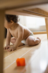 Baby boy sitting under table. - MINF02450