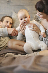 A mother, father and young baby playing at home. - MINF02480