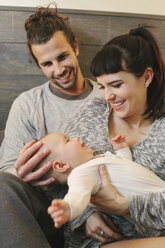 A mother, father and young baby playing at home. - MINF02481