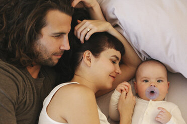 Eine Mutter, ein Vater und ein kleines Baby spielen zu Hause. - MINF02484