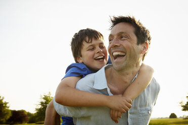 A father giving his son a piggyback. - MINF02500