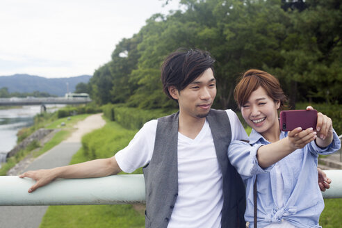 Ein Paar, ein Mann und eine Frau, in einem Park in Kyoto. - MINF02521