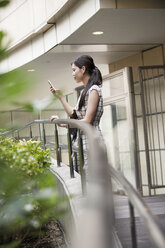Eine Frau auf einem Gehweg im Büro- und Einkaufskomplex Namba Park. - MINF02560