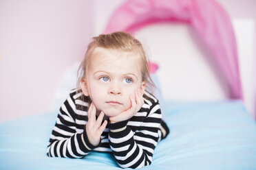 Porträt eines kleinen Mädchens, das zu Hause auf dem Bett liegt und träumt - NMSF00197