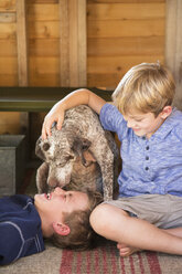 Zwei Brüder spielen mit ihrem Hund. - MINF02631