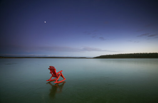 A small red rocking horse, on a frozen lake. - MINF02655