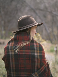 Young blond woman wearing a hat, wrapped in a blanket. - MINF02701