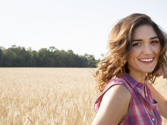 Young woman standing in a cornfield, smiling at the camera. - MINF02720