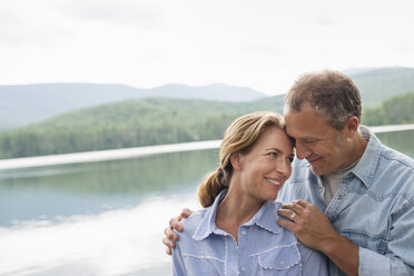 A mature couple standing by a lake shore. - MINF02729