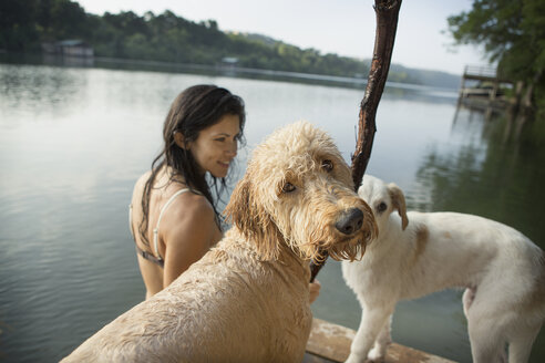 Eine Frau schwimmt mit ihren beiden Hunden in einem See. - MINF02735