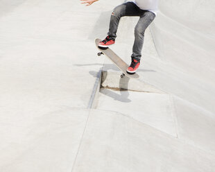 Ein Jugendlicher balanciert auf einem Skateboard durch die Stadt. - MINF02737
