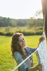 A woman hanging laundry on the washing line, in the fresh air. - MINF02754