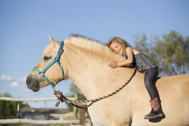 Ein junges Mädchen sitzt auf einem Pferd. - MINF02822