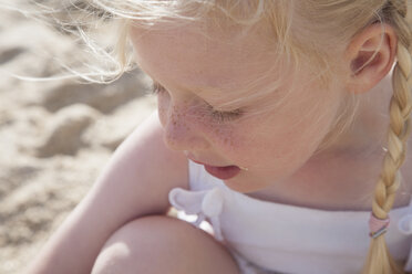 A young girl with blonde hair in pigtails on the beach. - MINF02872