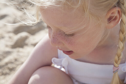 Ein junges Mädchen mit blondem Haar in Zöpfen am Strand. - MINF02872