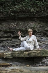 Ältere Frau beim Yoga auf dem Felsen, Halbwirbelsäulendrehung - ALBF00584