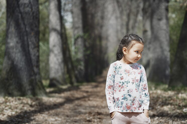Kleines Mädchen im Park stehend, mit Händen in den Taschen - AZF00012