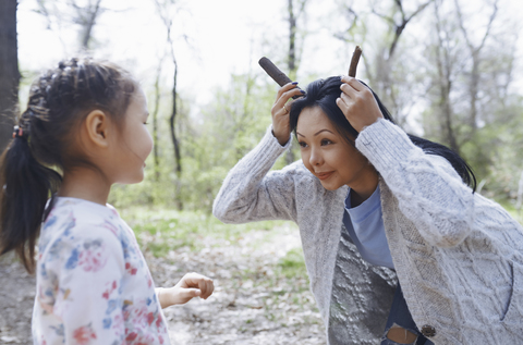 Mutter spielt mit kleiner Tochter in einem Park, lizenzfreies Stockfoto