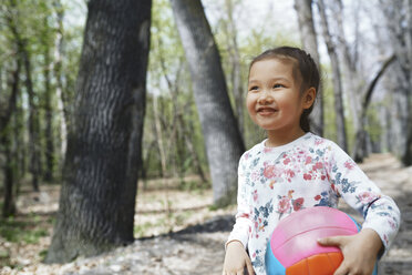 Kleines Mädchen spielt mit einem Ball in einem Park - AZF00021