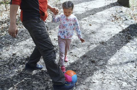 Vater und Tochter spielen Fußball im Park, lizenzfreies Stockfoto