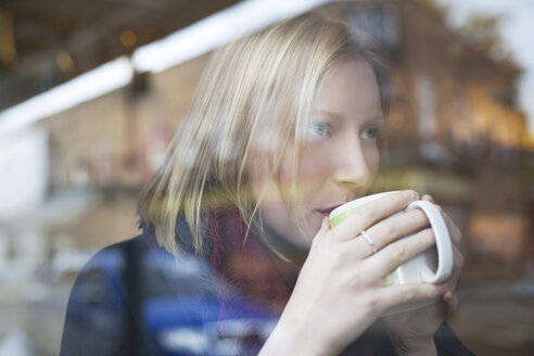 Frau trinkt eine Tasse Kaffee in einem Cafe - ISF17199
