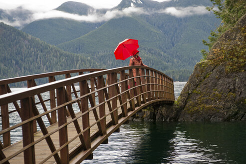 Frau mit Regenschirm auf Holzbrücke - ISF17227