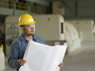 Engineer reading blueprints on site - ISF17241