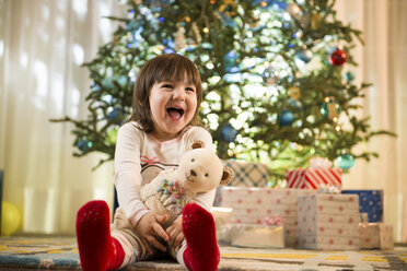 Girl laughing by Christmas tree - ISF17283