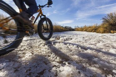 Mountainbiker auf Schnee in einem ländlichen Gebiet - ISF17328