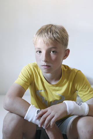 Porträt eines ernsten blonden Jungen mit Schweißbändern, lizenzfreies Stockfoto