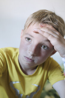 Porträt eines nachdenklichen blonden Jungen mit gelbem T-Shirt - KMKF00433